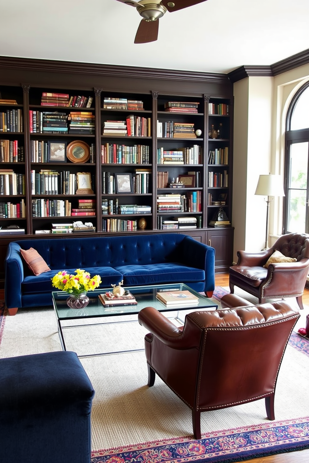 A cozy home library featuring a blend of vintage and modern furnishings. A large, plush velvet sofa in deep blue contrasts with a sleek glass coffee table at the center of the room. The walls are lined with dark wooden bookshelves filled with an eclectic collection of books and decorative items. A vintage armchair in rich leather sits in the corner next to a contemporary floor lamp, providing a perfect reading nook.