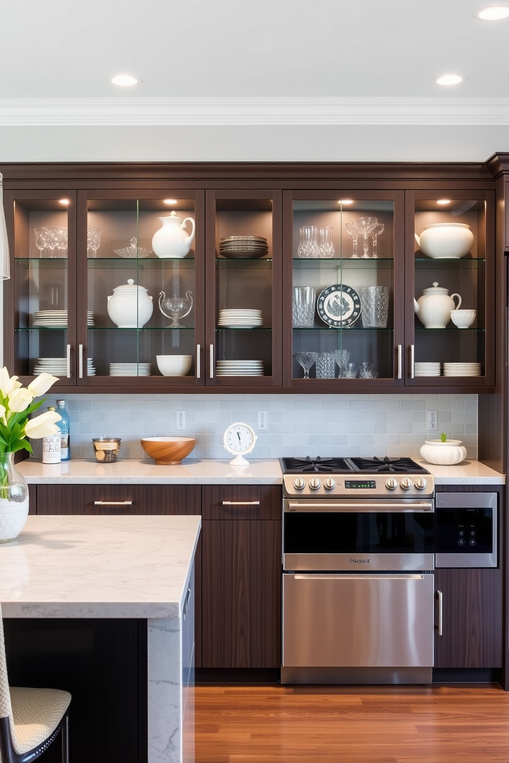 A modern kitchen featuring glass-front cabinets that showcase elegant dishware and decorative items. The cabinetry is complemented by sleek stainless steel appliances and a large central island with bar seating.