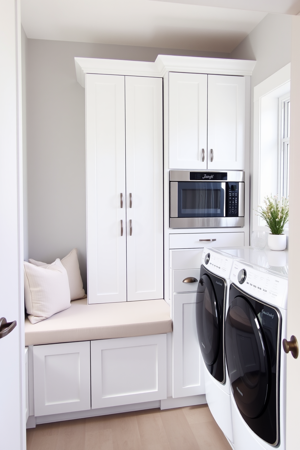 A modern laundry room featuring a sleek white cabinetry system with built-in appliances. A comfortable bench is placed against one wall, adorned with soft cushions for added seating and style. The walls are painted in a light gray hue, providing a clean and airy feel. A stylish backsplash in a geometric pattern complements the overall design, while a large window allows natural light to flood the space.