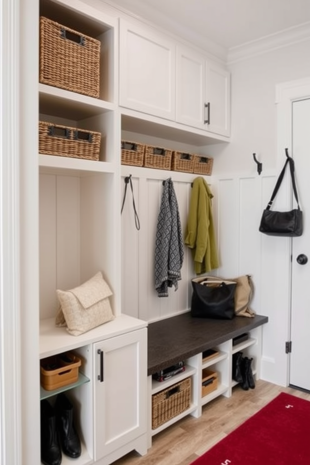 A bright and inviting mudroom features a built-in bench with plush cushions and hooks for hanging coats. The walls are painted in a soft gray, complemented by a patterned area rug and baskets for storage. Seasonal decor includes a wreath made of autumn leaves on the door and a cozy throw blanket draped over the bench. Decorative pumpkins and candles are arranged on a side table to create a warm and welcoming atmosphere.