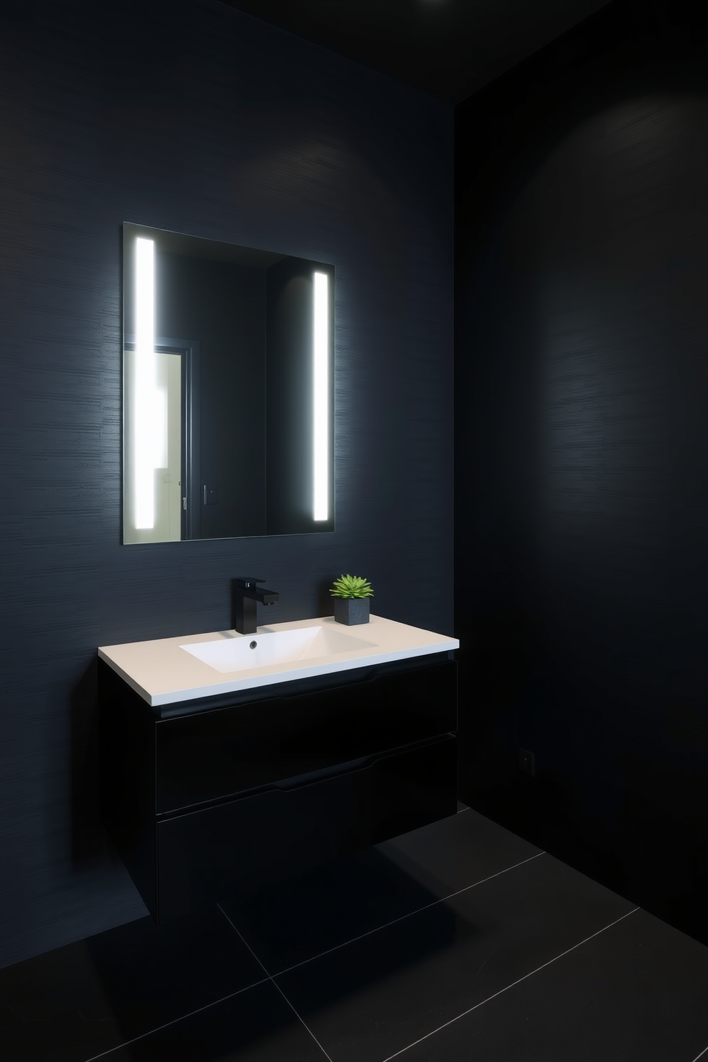 A sleek black mirror is mounted above a minimalist black vanity with a polished white countertop. The walls are adorned with dark, textured wallpaper, creating a moody atmosphere complemented by soft, ambient lighting. The floor features large, matte black tiles that enhance the room's modern elegance. A small potted plant sits on the vanity, adding a touch of greenery to the sophisticated design.