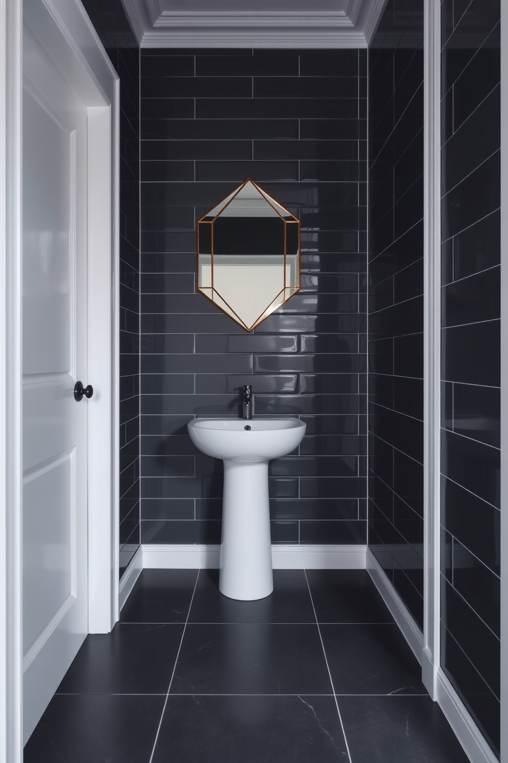 Charcoal gray tiles cover the floor and walls, creating a dramatic backdrop for the space. The white trim adds a crisp contrast, highlighting the elegant lines of the design. A sleek pedestal sink is positioned against one wall, complemented by a modern faucet. Above the sink, a stylish mirror with a geometric frame reflects the moody ambiance of the room.