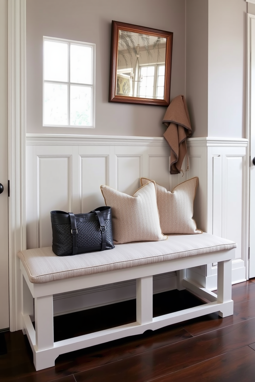 A simple bench with a natural wood stain is placed against the wall in the mudroom. The bench features clean lines and a minimalist design, complemented by soft cushions in neutral tones for added comfort.