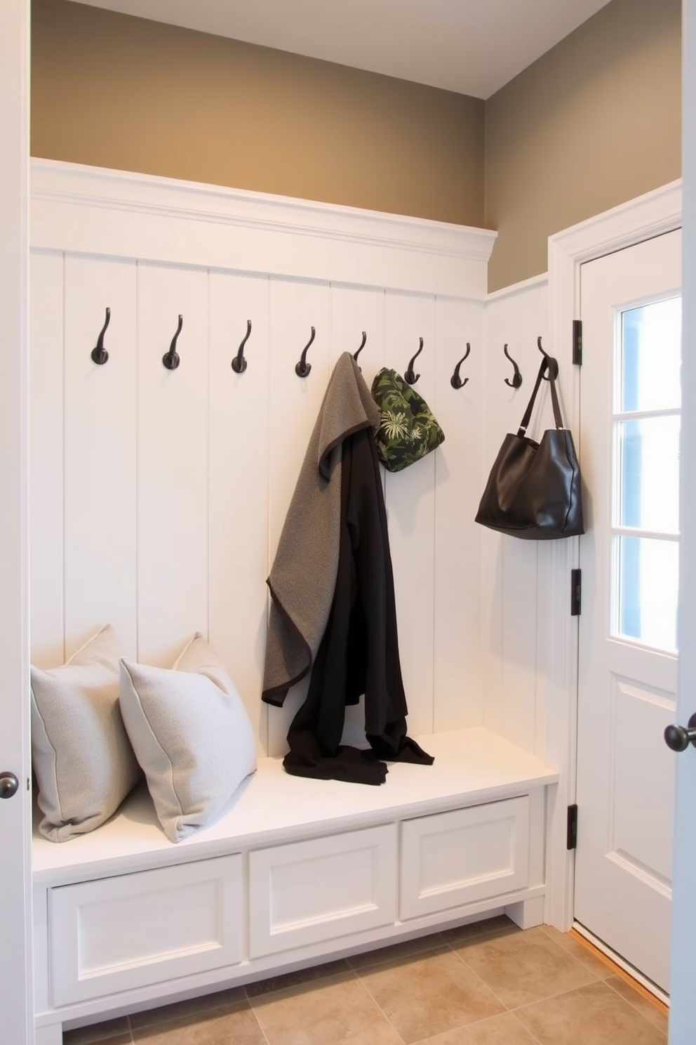 A stylish mudroom features a bench with a pop of bright color that draws the eye and adds vibrancy to the space. The bench is adorned with plush cushions and is complemented by hooks on the wall for hanging coats and bags. Surrounding the bench are built-in storage cubbies that provide ample space for shoes and outdoor gear. The flooring is durable and easy to clean, ensuring the area remains functional and inviting.