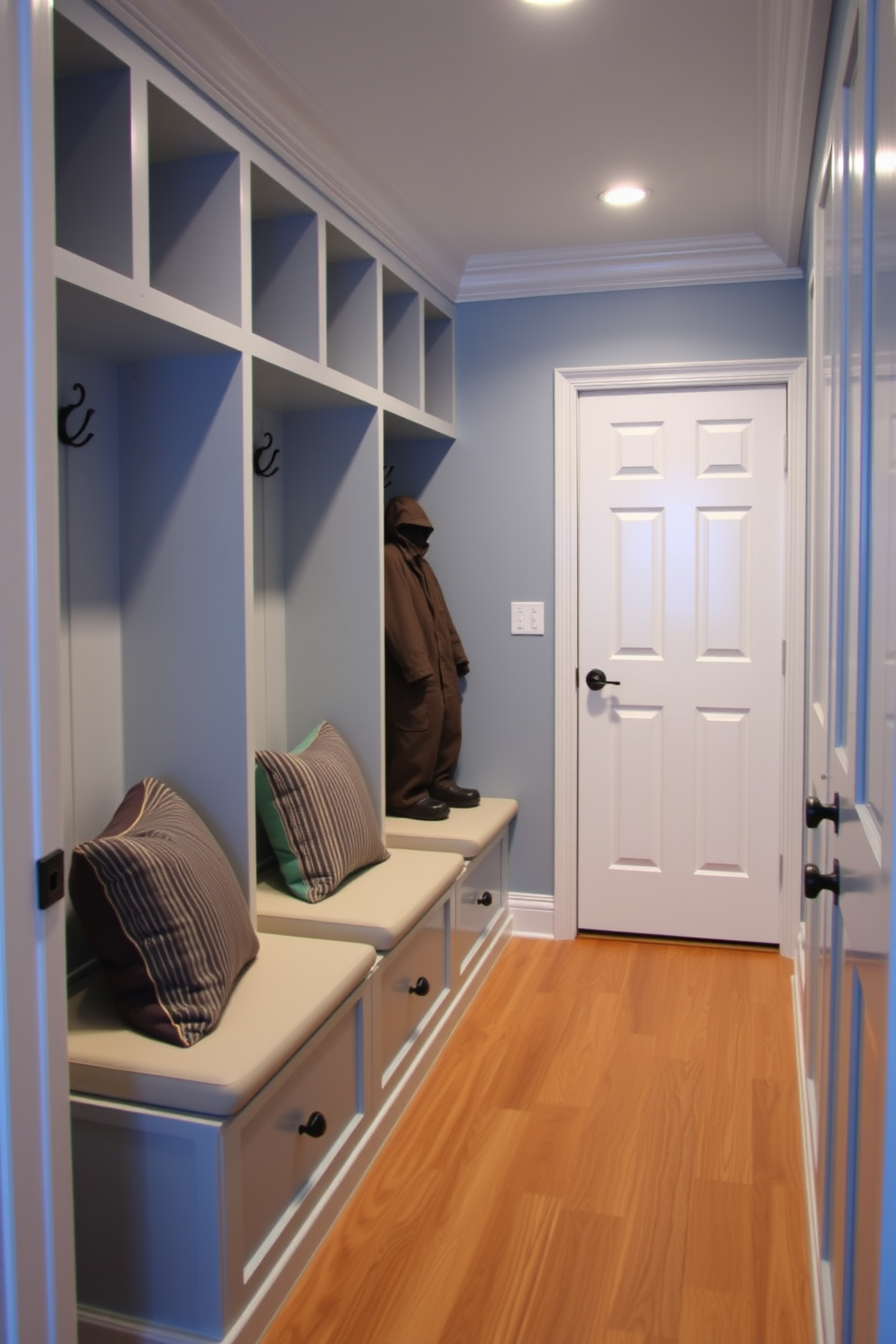 A cozy mudroom features built-in cubbies with cushioned seating pads for comfort. The cubbies are painted in a soft blue hue, providing a welcoming contrast to the warm wood flooring.