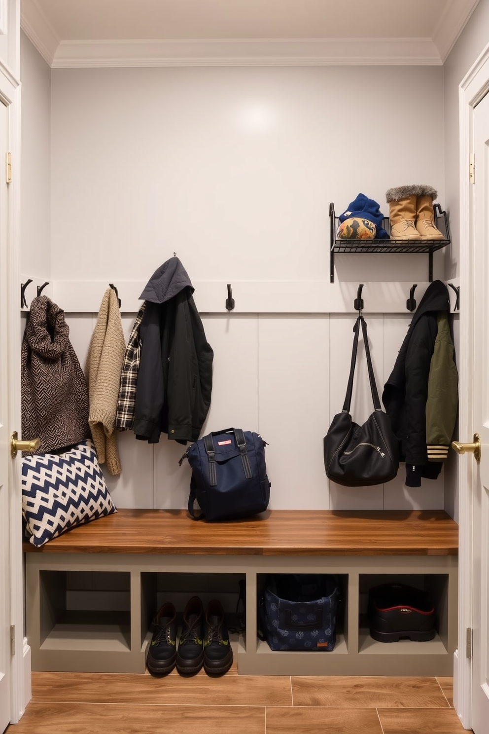 A functional mudroom featuring a wall-mounted drying rack for wet gear. The space includes built-in benches with storage underneath and hooks for hanging coats and bags.