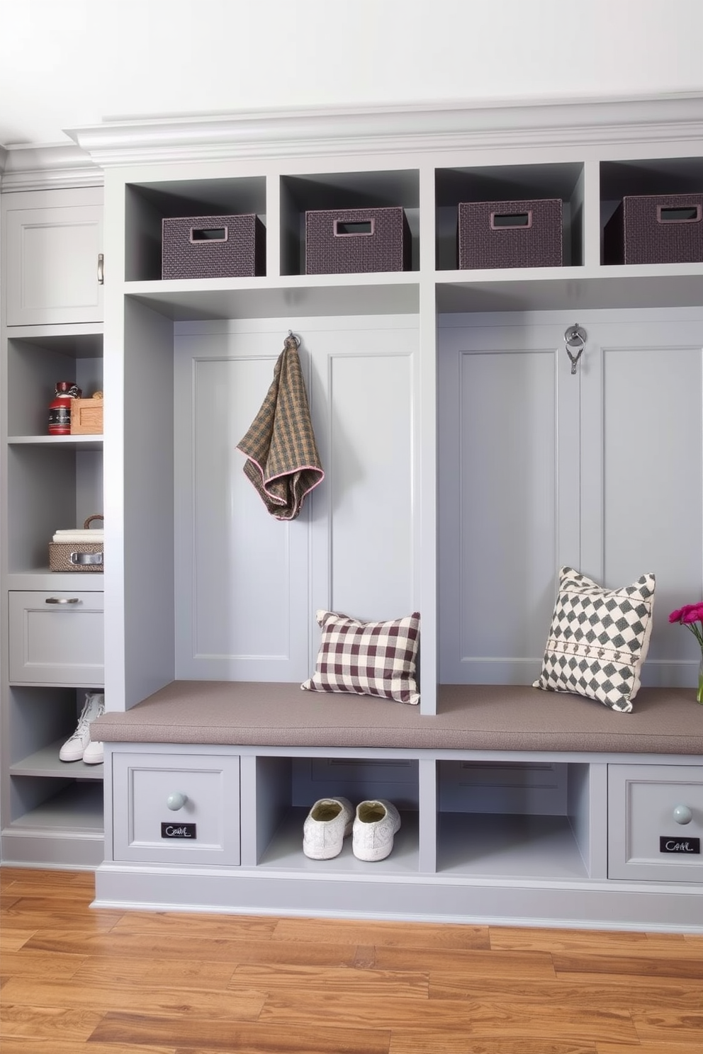 A stylish mudroom features built-in cubbies designed for organized storage. The cubbies are finished in a soft gray hue, complemented by a bench upholstered in a durable fabric.