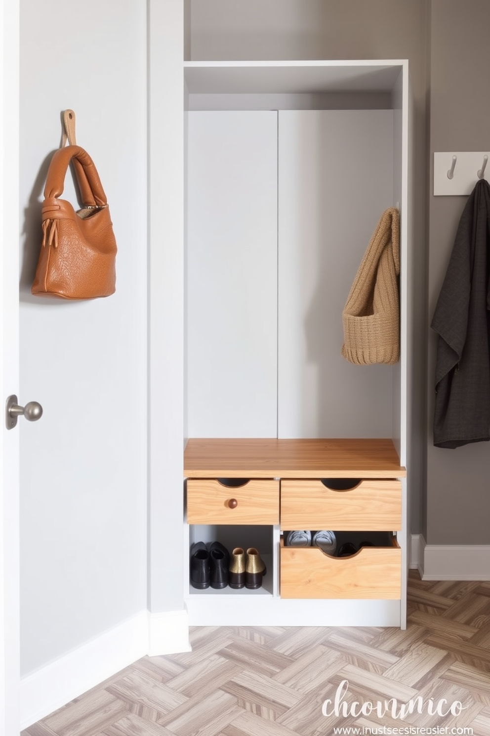 A stylish mudroom featuring a shoe storage unit with pull-out drawers made of natural wood. The walls are painted in a soft gray hue, complemented by a durable tile floor in a herringbone pattern.