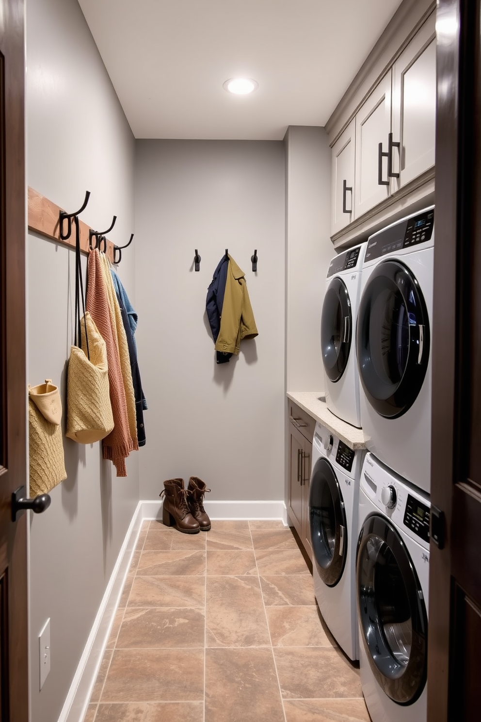 A functional mudroom featuring wall hooks for jackets and bags is designed with a rustic charm. The walls are painted in a soft grey, and the floor is covered with durable, patterned tiles for easy cleaning. Adjacent to the mudroom, the laundry room boasts a sleek washer and dryer setup with ample storage cabinets above. A countertop for folding clothes runs along one side, and a small sink is integrated for convenience.