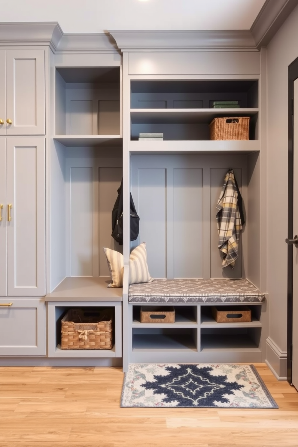 A bright and inviting mudroom features large windows that allow natural light to flood the space. The walls are painted in a soft white, complementing the warm wooden cabinetry and built-in bench with storage underneath. On the floor, a durable tile in a neutral tone is paired with a stylish area rug for added comfort. Hooks line the walls for hanging coats and bags, while a decorative basket holds shoes neatly organized.