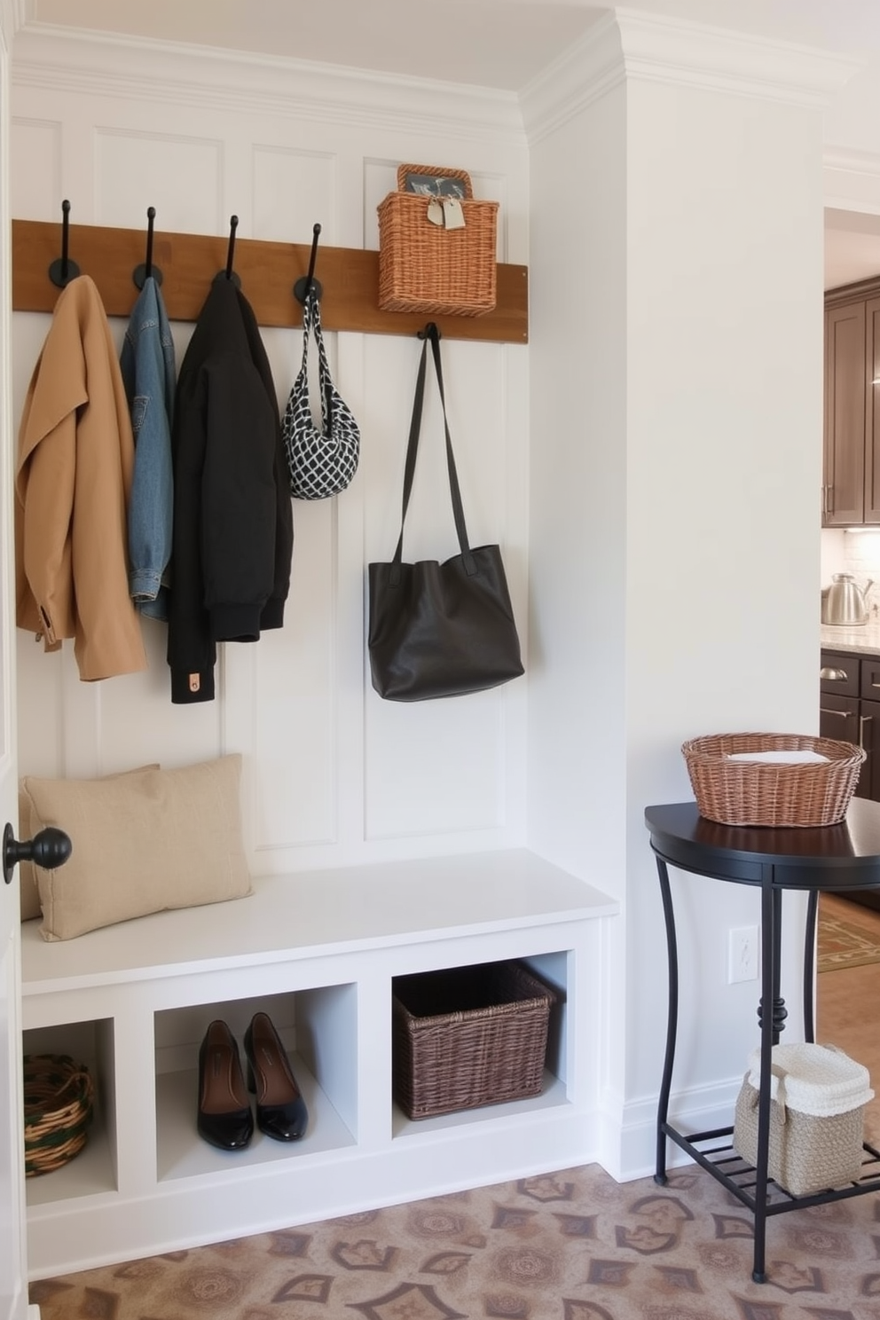 A functional drop zone for everyday items features a built-in bench with storage cubbies underneath. Above the bench, there are hooks for hanging coats and bags, and the walls are painted in a light, airy color to create an inviting atmosphere. The mudroom near the kitchen includes a stylish tile floor that is easy to clean and durable. A small table with a decorative bowl for keys and a basket for shoes adds organization and charm to the space.