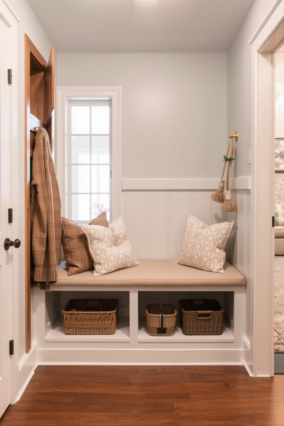 A functional storage bench with hooks is positioned in the mudroom near the living room entrance. The bench features a soft cushion on top, while the hooks are arranged above it for hanging coats and bags, creating an organized and welcoming space.