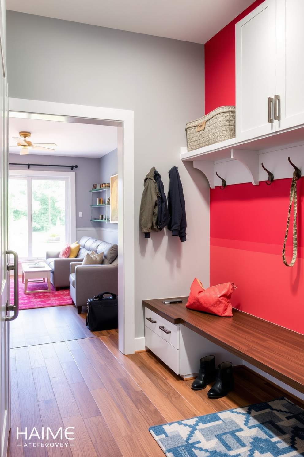 A modern mudroom designed for convenience features smart technology integrated into the space. There are built-in benches with storage compartments and charging stations for devices, all accented by sleek cabinetry and a vibrant accent wall. Adjacent to the living room, the mudroom offers a seamless transition with stylish hooks for coats and bags. Natural light floods the area through a large window, enhancing the inviting atmosphere while maintaining functionality.