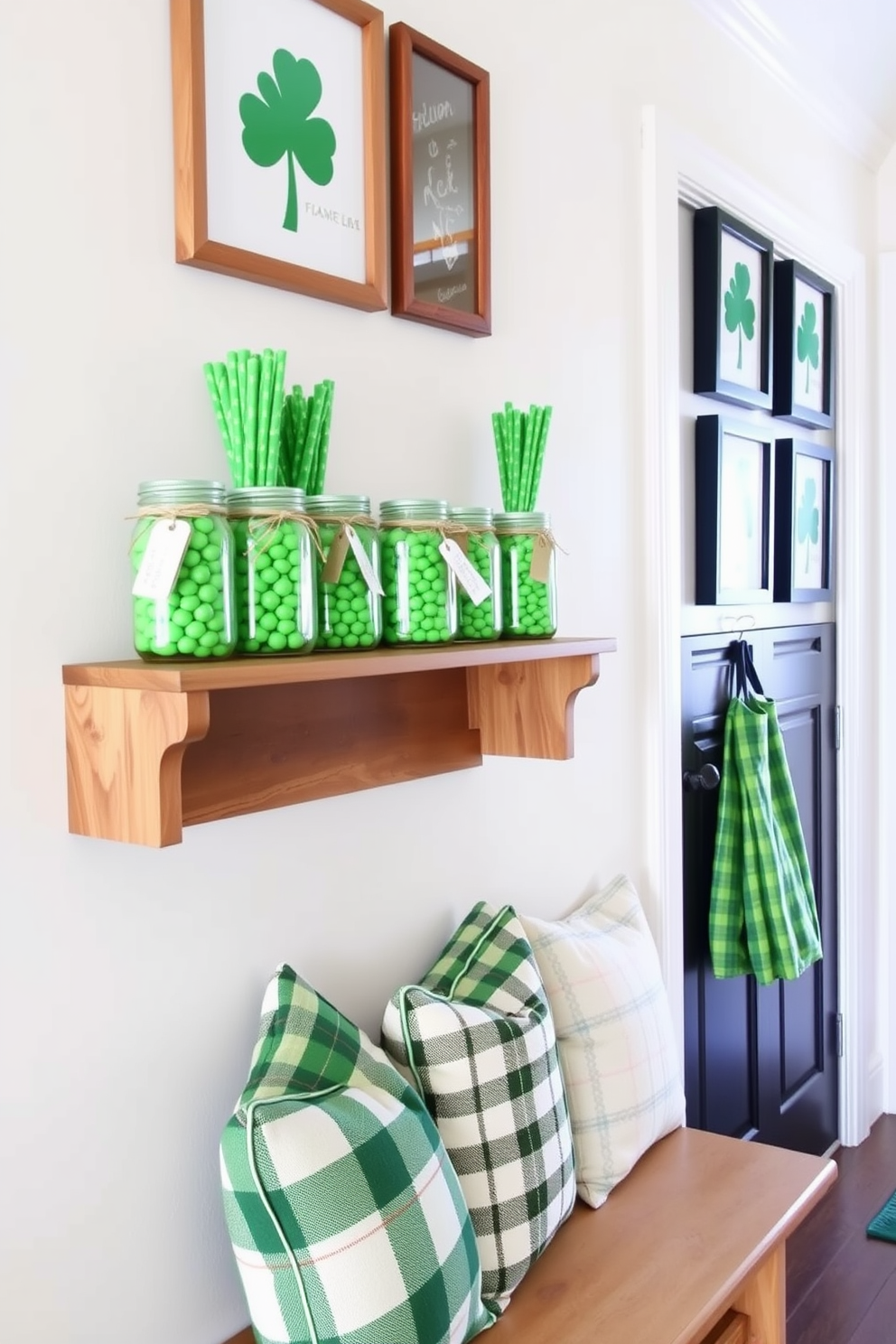 Mason jars filled with vibrant green candies are arranged on a rustic wooden shelf. The jars are adorned with twine and small tags, creating a charming display perfect for St. Patrick's Day. The mudroom features a cozy bench with green and white plaid cushions. Above the bench, a collection of shamrock-themed artwork adds a festive touch to the space.