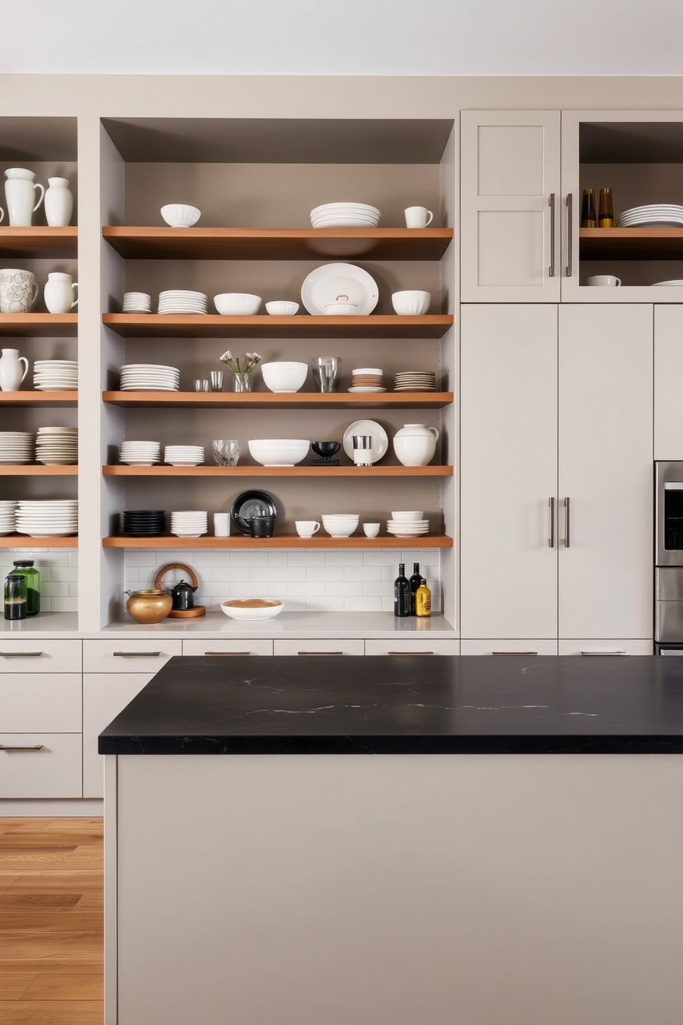 A modern kitchen featuring open shelving that showcases a curated collection of dishware and decorative items. The cabinetry is sleek and minimalistic, with a large island at the center topped with a contrasting dark stone surface.