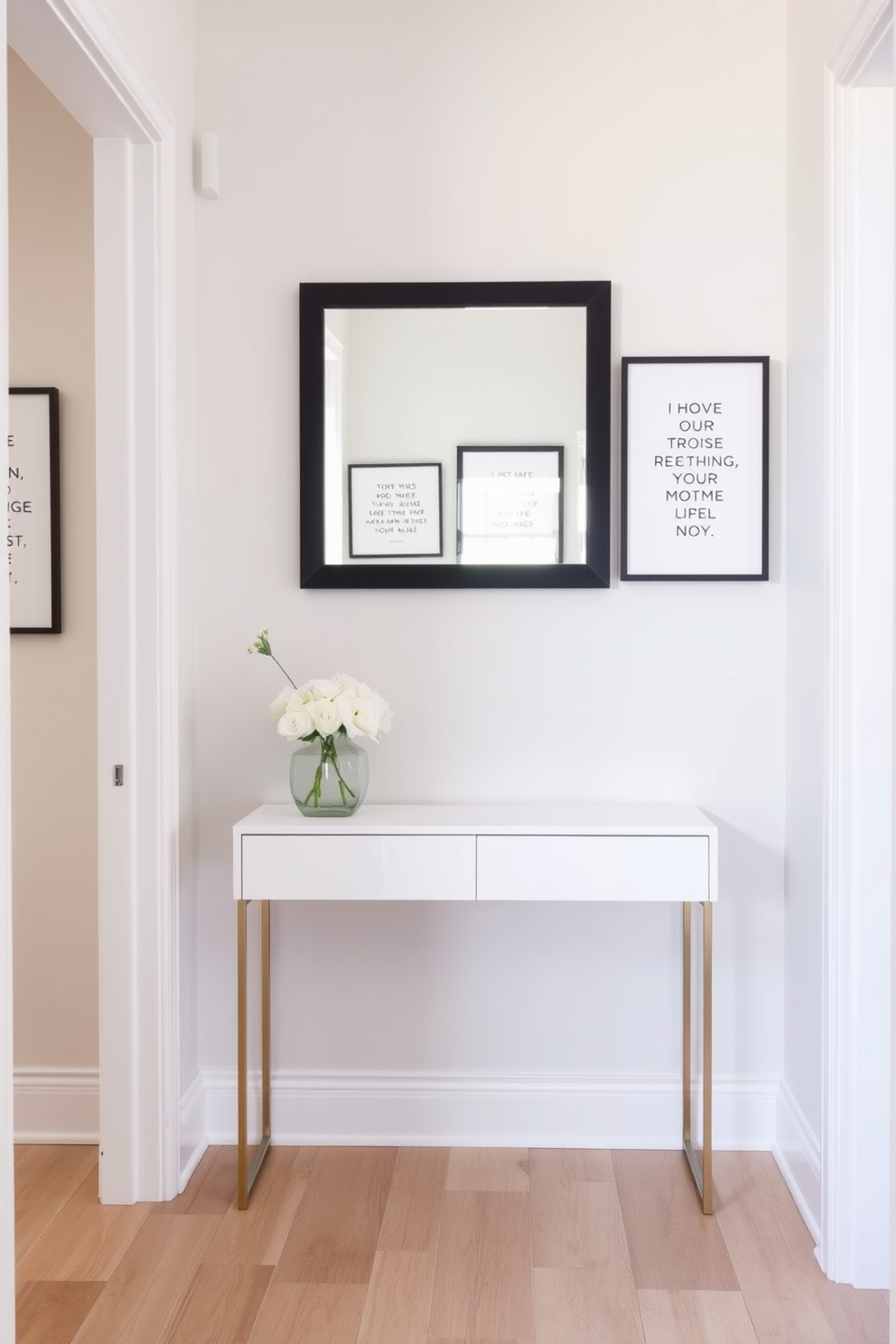 A narrow foyer featuring a sleek console table with a minimalist design. The walls are adorned with framed wall art showcasing inspirational quotes in elegant typography. The flooring is a light hardwood that complements the soft color palette of the space. A stylish mirror hangs above the console table, reflecting natural light and creating an inviting atmosphere.