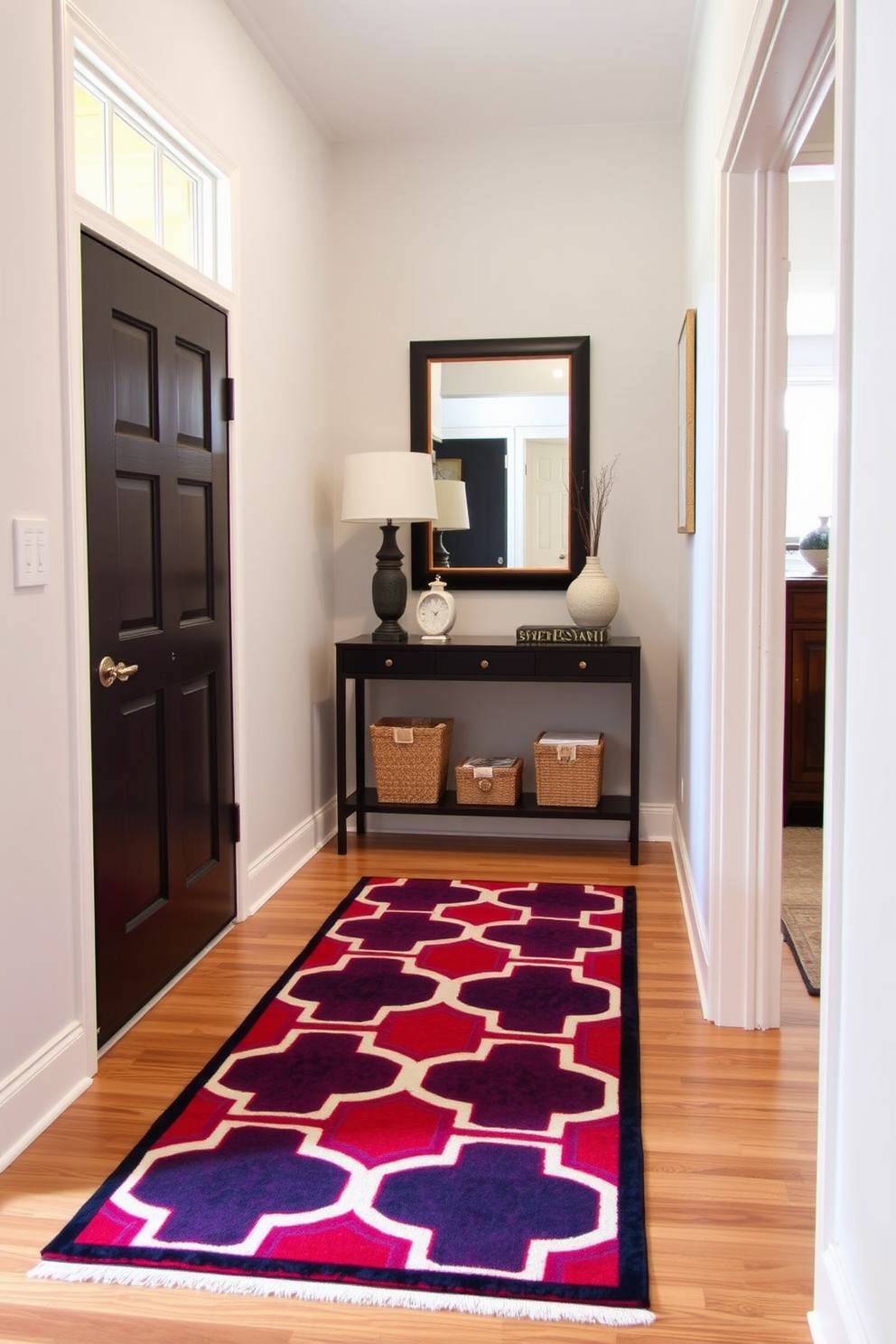 A stylish runner rug adds warmth and character to a narrow foyer. The rug features a bold geometric pattern in vibrant colors that contrasts beautifully with the neutral walls and flooring. Incorporating a narrow console table against one wall provides a functional space for decor and storage. Above the table, a large mirror enhances the sense of openness and reflects light throughout the area.