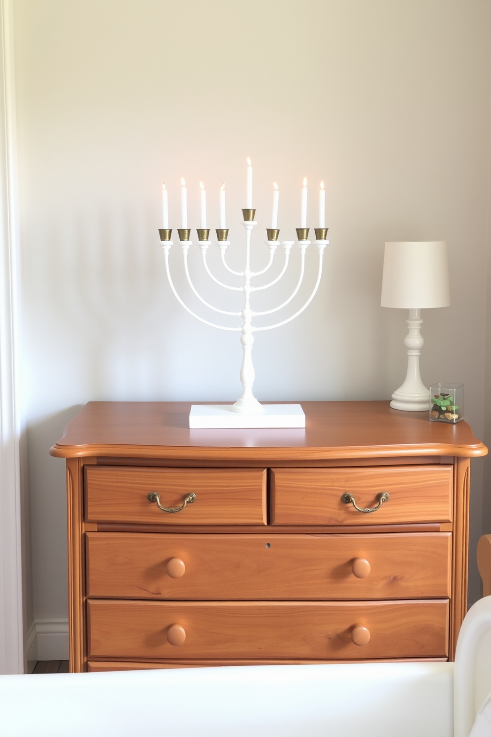 A handmade menorah centerpiece is elegantly displayed on a beautifully crafted wooden dresser. The dresser is adorned with soft pastel colors, creating a warm and inviting atmosphere for the nursery during Hanukkah.