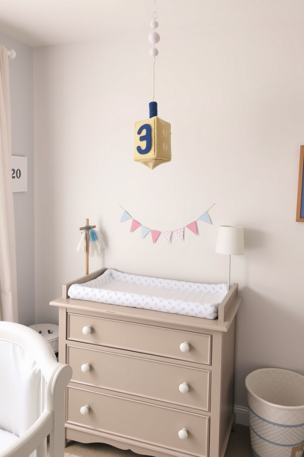 A whimsical nursery featuring a changing table adorned with a felt dreidel mobile hanging above. The walls are painted in soft pastel colors, and the decor includes subtle Hanukkah-themed accents to create a festive yet cozy atmosphere.