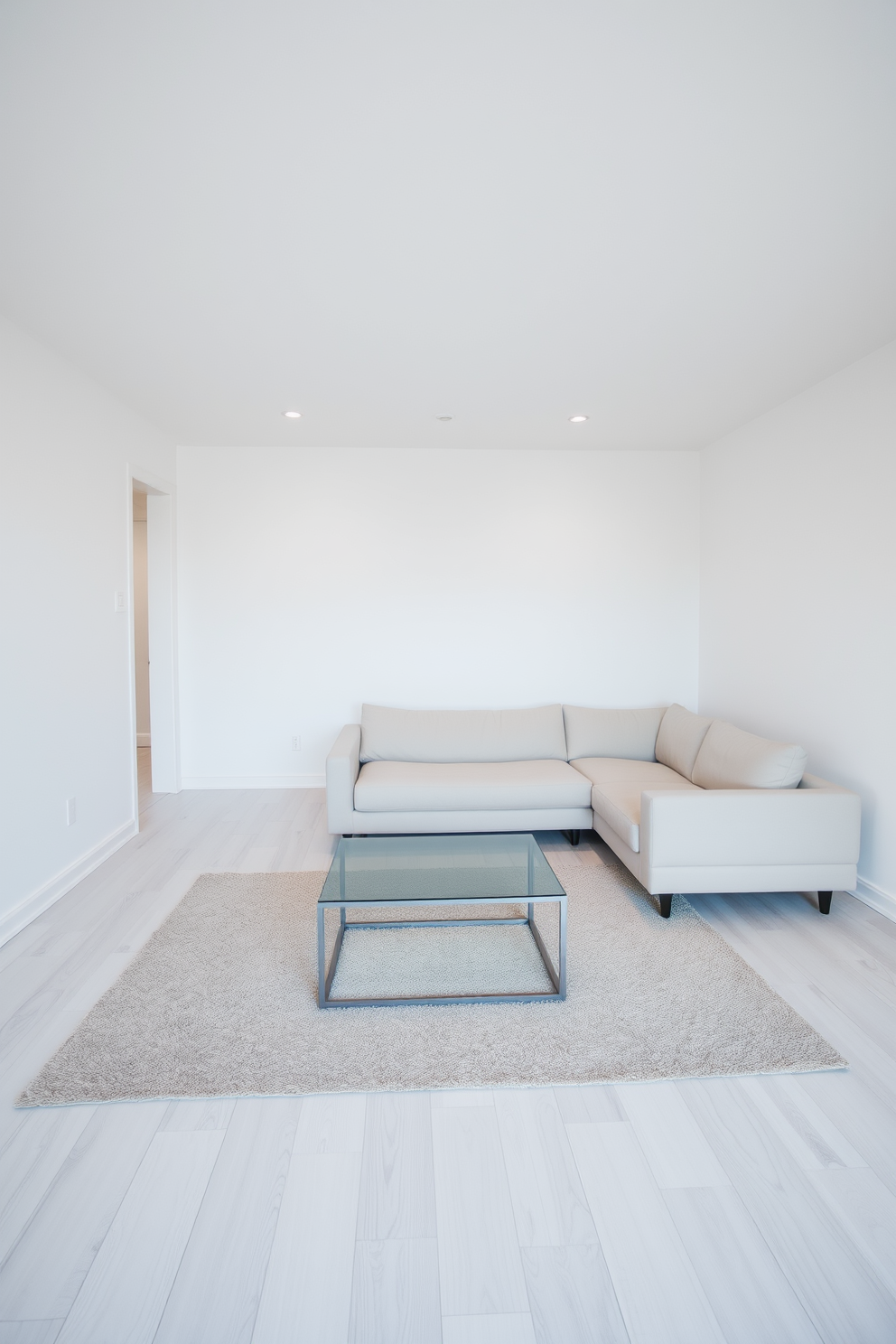 A serene open basement design featuring minimalist decor. The space is characterized by a light color palette, with white walls and a pale wood floor creating a clean aesthetic. In one corner, a simple sectional sofa in a neutral tone invites relaxation. A sleek coffee table made of glass and metal sits atop a soft area rug, enhancing the uncluttered feel of the room.