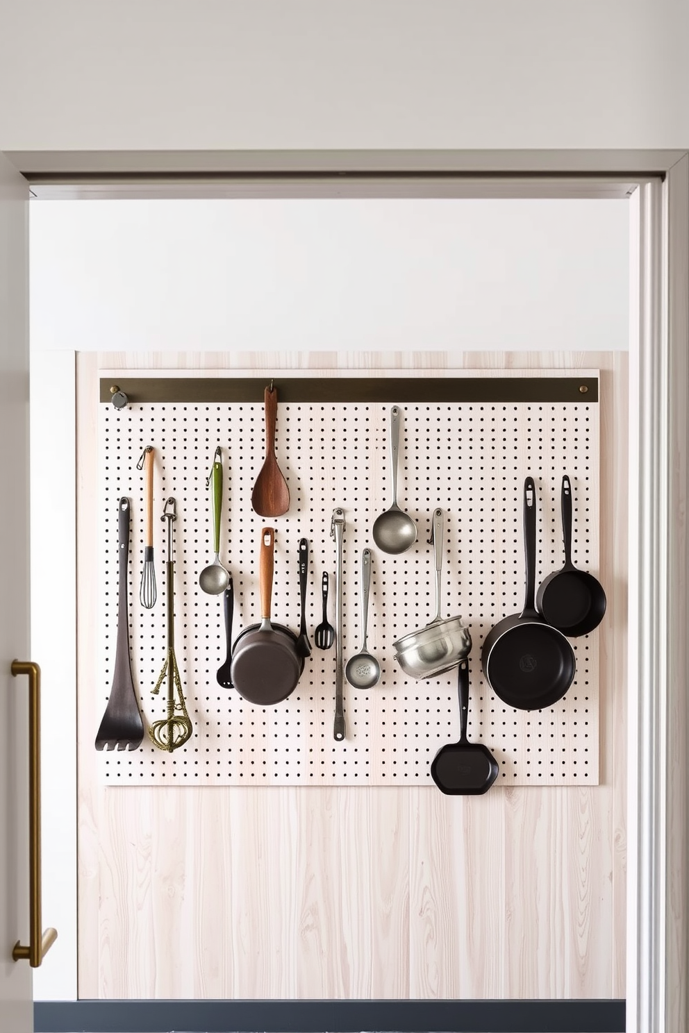 A modern open pantry design featuring a pegboard for hanging kitchen items. The pegboard is mounted on a light wood wall, showcasing various utensils and pots for easy access.