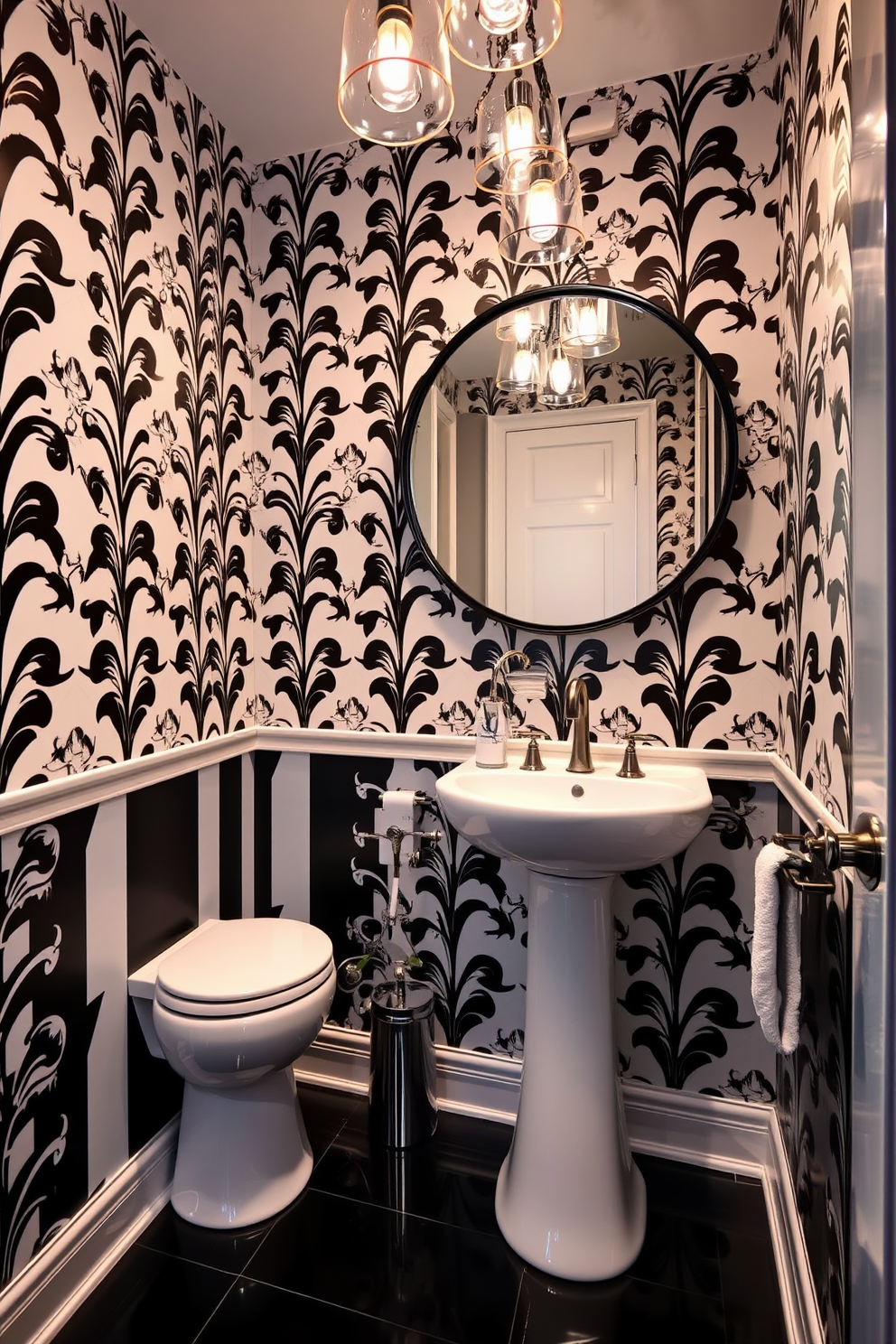 A stylish powder room featuring a black and white color scheme. The walls are adorned with bold black and white wallpaper, while the floor is covered in sleek black tiles. A modern pedestal sink with a glossy white finish sits against one wall. Above the sink, a large round mirror with a black frame reflects the elegant lighting fixtures hanging from the ceiling.