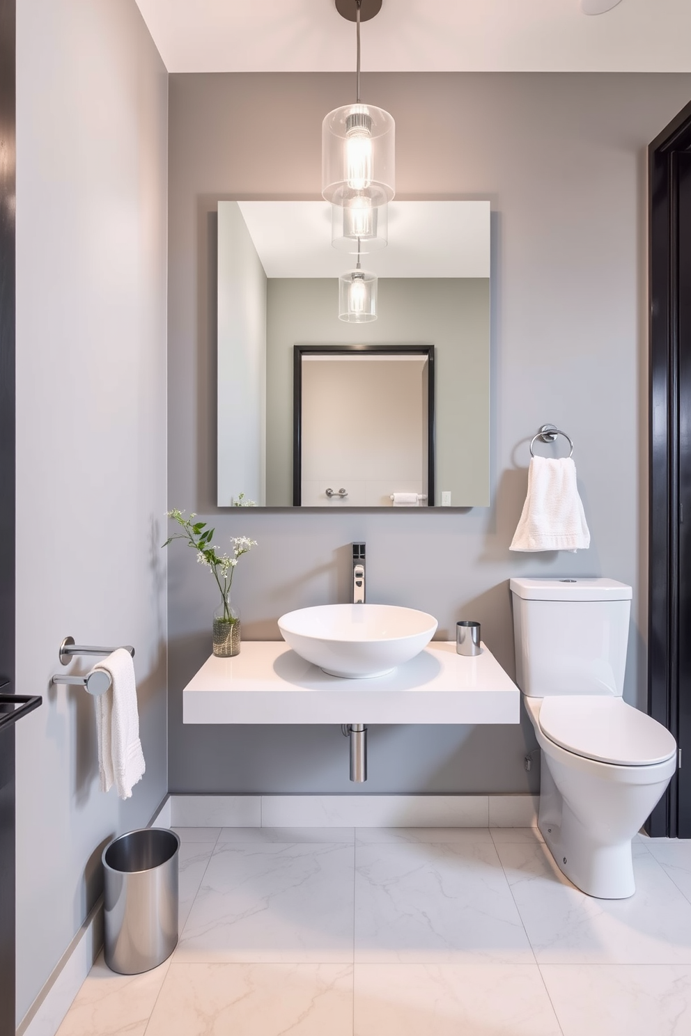 A stylish powder room featuring modern fixtures with sleek designs. The walls are adorned with a soft gray paint, while a minimalist floating vanity showcases a vessel sink and polished chrome faucet. A large frameless mirror reflects the elegant lighting above, creating an inviting atmosphere. The floor is covered in large format tiles with a subtle marble effect, enhancing the room's contemporary feel.