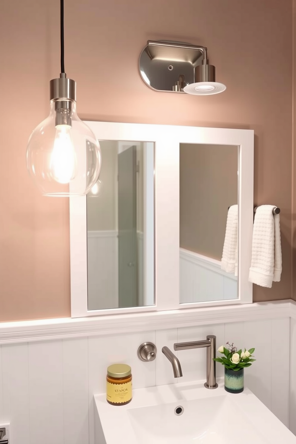 Chic pendant lights hang elegantly above the sink in the powder room, casting a warm and inviting glow. The fixtures feature a modern design with a brushed nickel finish, perfectly complementing the sleek white cabinetry.