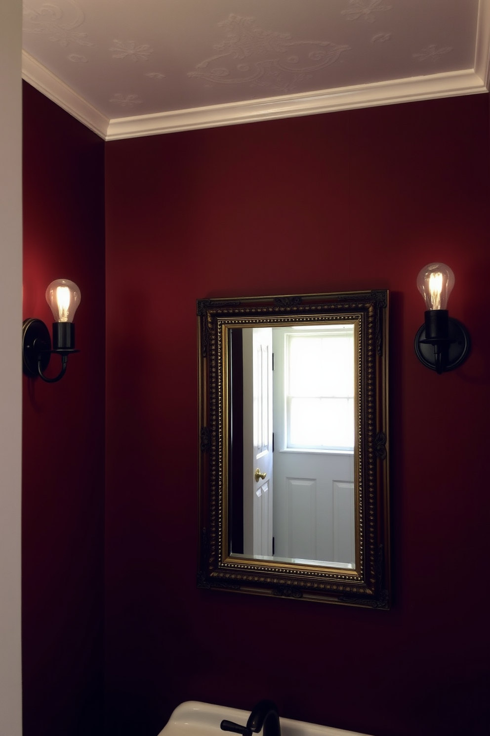 A charming powder room features vintage sconces with Edison bulbs mounted on either side of a beautifully framed mirror. The warm glow of the bulbs enhances the rich color of the walls, creating an inviting atmosphere.