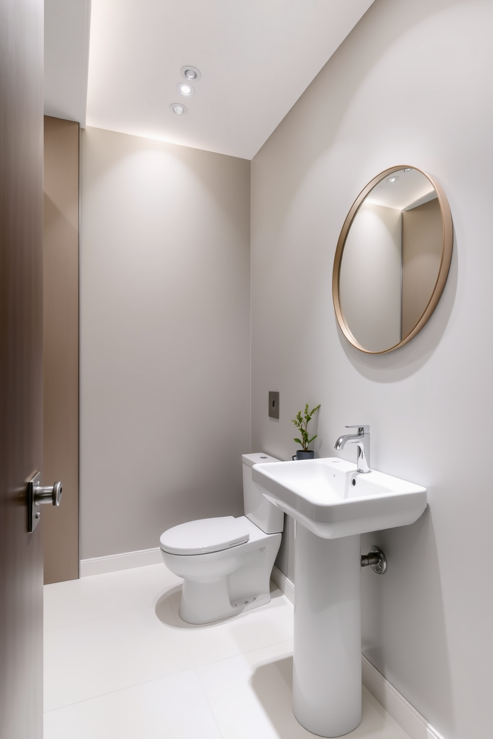 A chic powder room featuring recessed lighting that creates a sleek and modern atmosphere. The walls are painted in a soft gray, and the floor is adorned with large white tiles that enhance the brightness of the space. A stylish pedestal sink is positioned against the wall, complemented by a wall-mounted faucet that adds to the minimalist design. Above the sink, a round mirror reflects the elegant lighting, while a small potted plant adds a touch of greenery to the room.