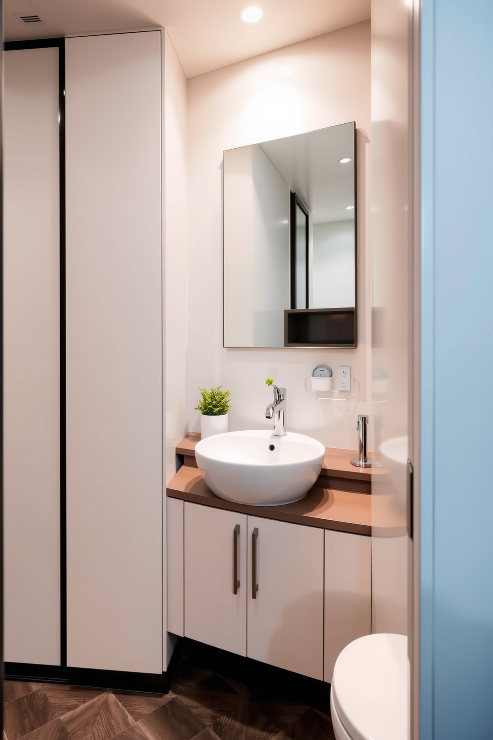 A compact sink is elegantly integrated into a small powder room featuring sleek cabinetry and a minimalist design. The walls are adorned with soft pastel colors, and a stylish mirror enhances the sense of space and light. The sink is complemented by modern fixtures and a small shelf above it for decorative items. A touch of greenery is added with a small potted plant on the countertop, creating a fresh and inviting atmosphere.