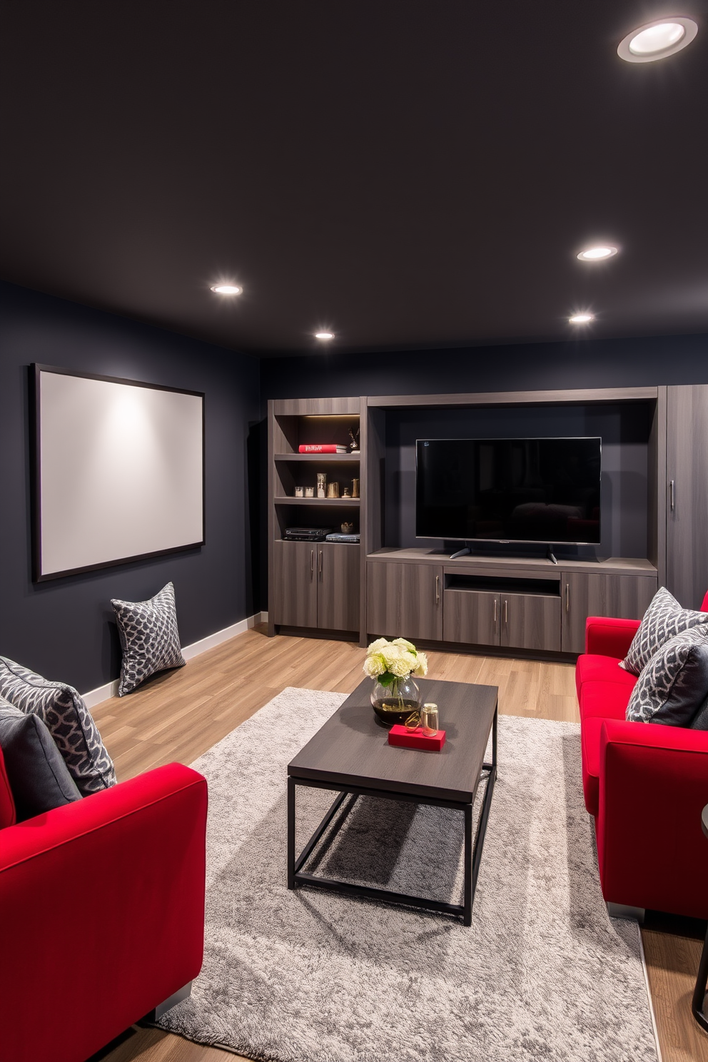 A stylish basement retreat featuring a red and grey color scheme. The walls are painted a deep charcoal grey, while the furniture includes a plush red sectional sofa complemented by grey accent pillows. A sleek entertainment center in a matching grey houses a large flat-screen TV. Soft ambient lighting highlights the space, and a contemporary coffee table sits atop a textured grey area rug.