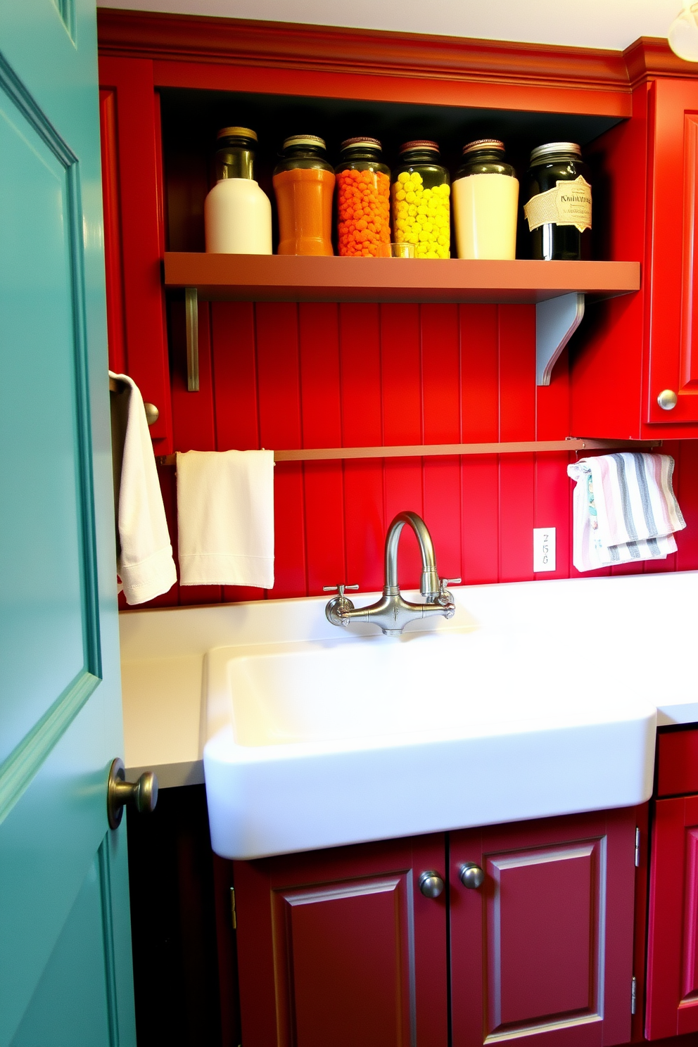 A vintage laundry room featuring a red and aqua color scheme. The walls are painted a soft aqua, while the cabinetry is a deep, rich red, creating a warm and inviting atmosphere. A large farmhouse sink sits prominently in the center, complemented by vintage-style faucets in a brushed nickel finish. Shelves above the sink display colorful laundry supplies in decorative jars, adding charm and functionality.