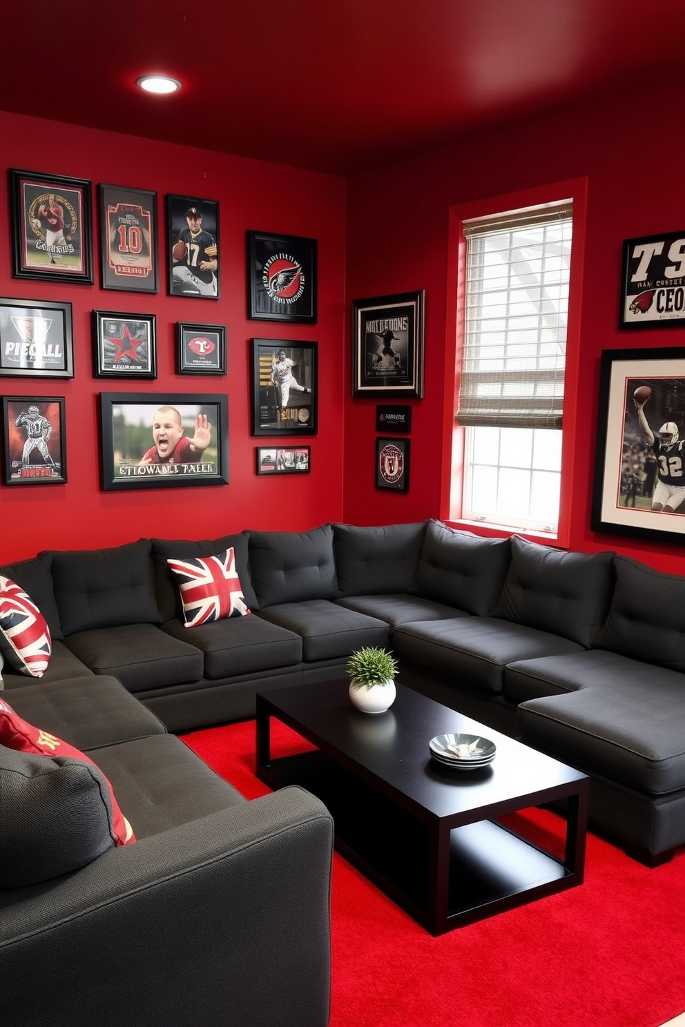 A cozy man cave featuring a rich red and gray color scheme. The walls are painted a deep red, complemented by gray upholstered furniture and accents throughout the space. A large sectional sofa in dark gray is positioned in front of a sleek black coffee table. A bold red area rug anchors the seating area, while framed sports memorabilia adorns the walls.