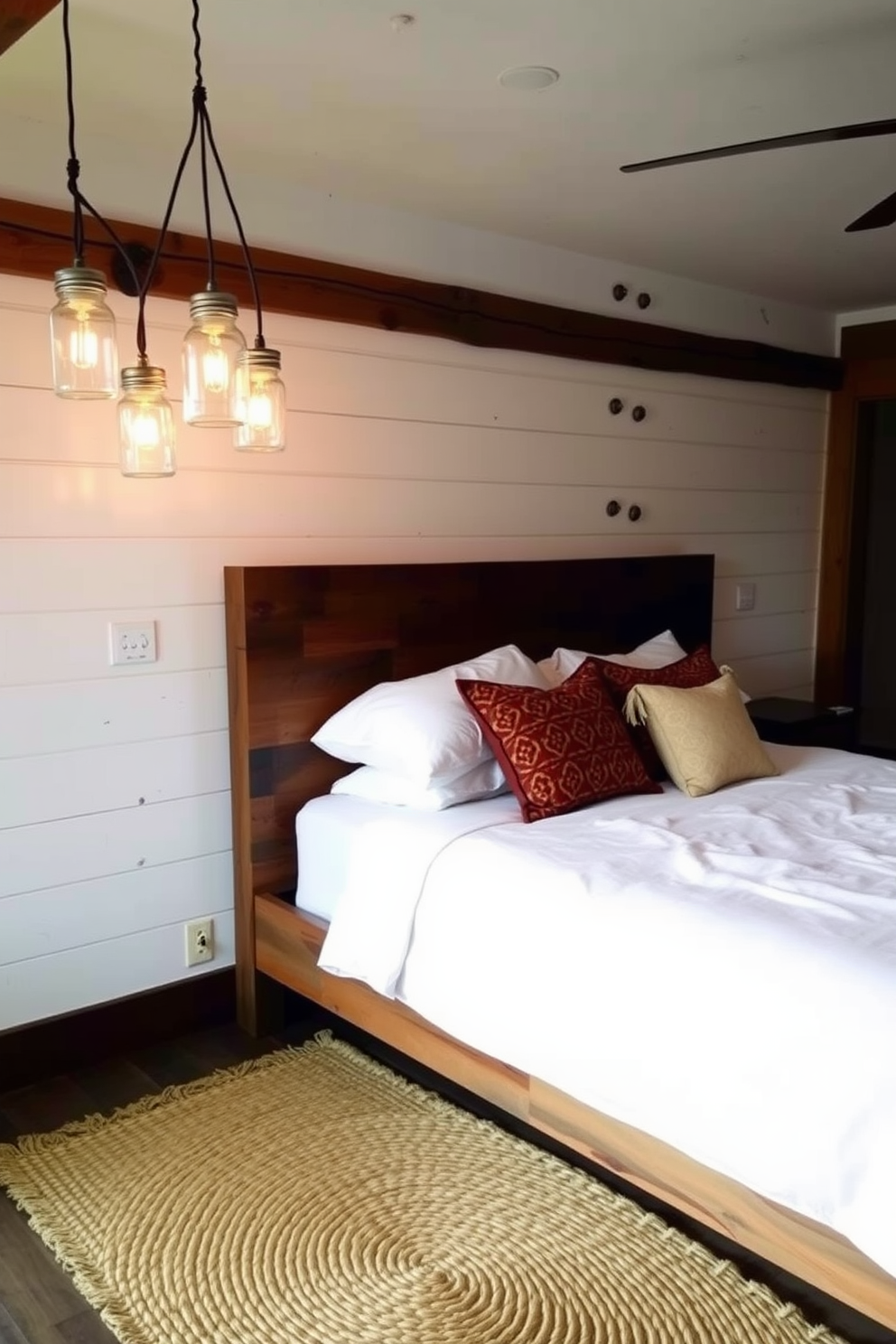 A rustic bedroom features mason jar lighting fixtures hanging above a reclaimed wood bed. The walls are adorned with shiplap, and a cozy woven rug lies beneath the bed, adding warmth to the space.