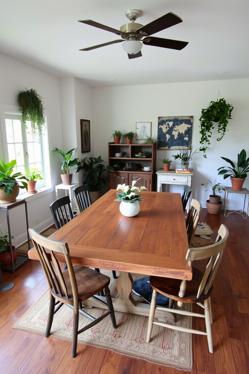 A rustic dining room featuring a large wooden table with a distressed finish surrounded by mismatched chairs. The room is adorned with potted plants placed in various corners, bringing a touch of nature indoors and enhancing the cozy atmosphere.