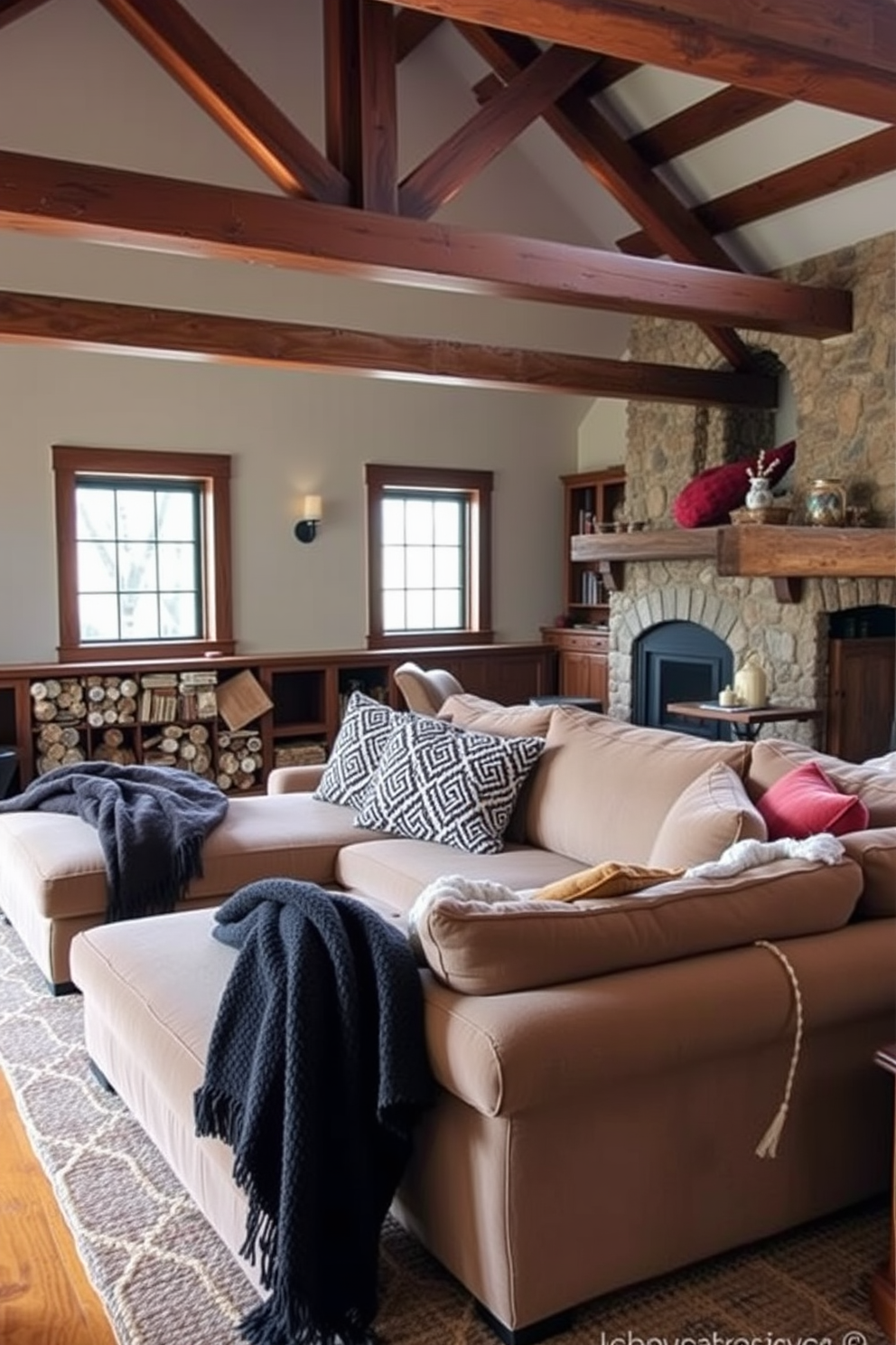 An oversized sectional sofa is adorned with cozy throw blankets in various textures and colors. The room features exposed wooden beams and a stone fireplace, creating a warm and inviting atmosphere.