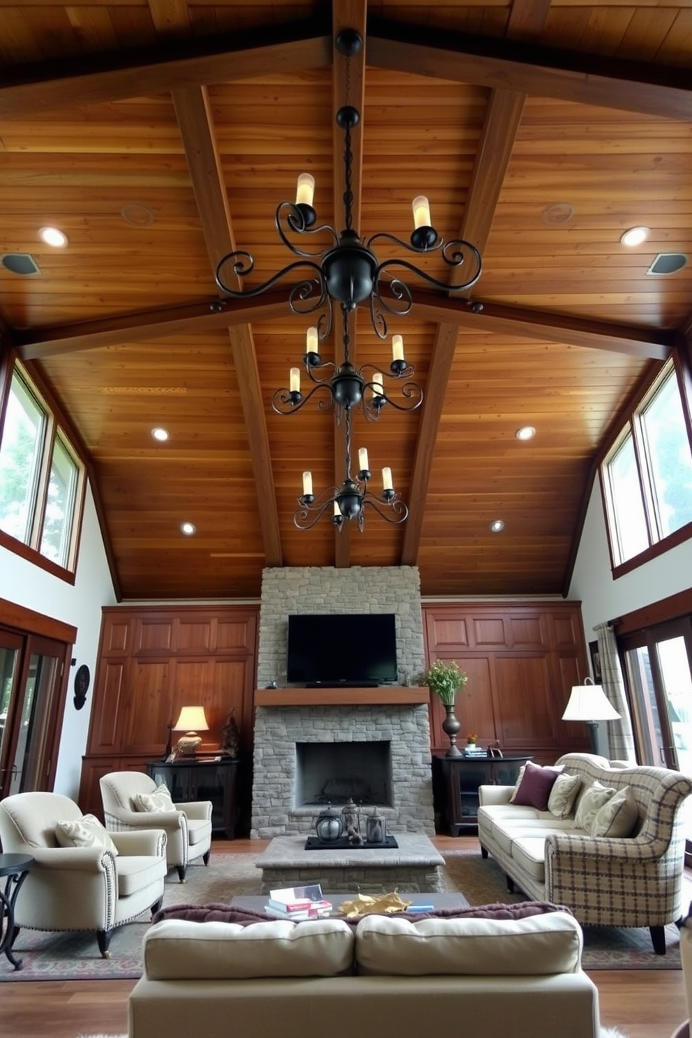 A cozy family room featuring a wooden ceiling adorned with wrought iron fixtures. The space is filled with comfortable seating, including a large sectional sofa and a pair of armchairs, all arranged around a stone fireplace.