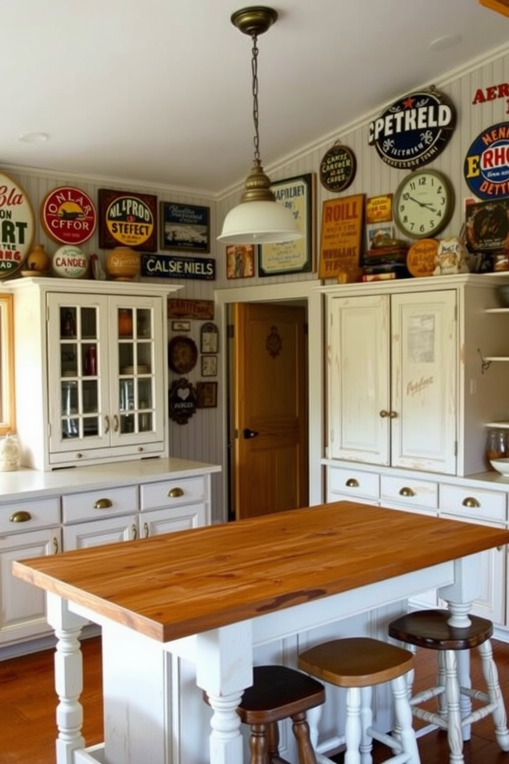 A rustic kitchen filled with vintage signs and artwork that reflect a warm and inviting atmosphere. The walls are adorned with various retro signs, while colorful artwork hangs above a farmhouse-style wooden table. The cabinets are painted in a distressed white finish, complemented by antique brass hardware. A large wooden island in the center features a butcher block top, surrounded by mismatched stools for a cozy, eclectic feel.