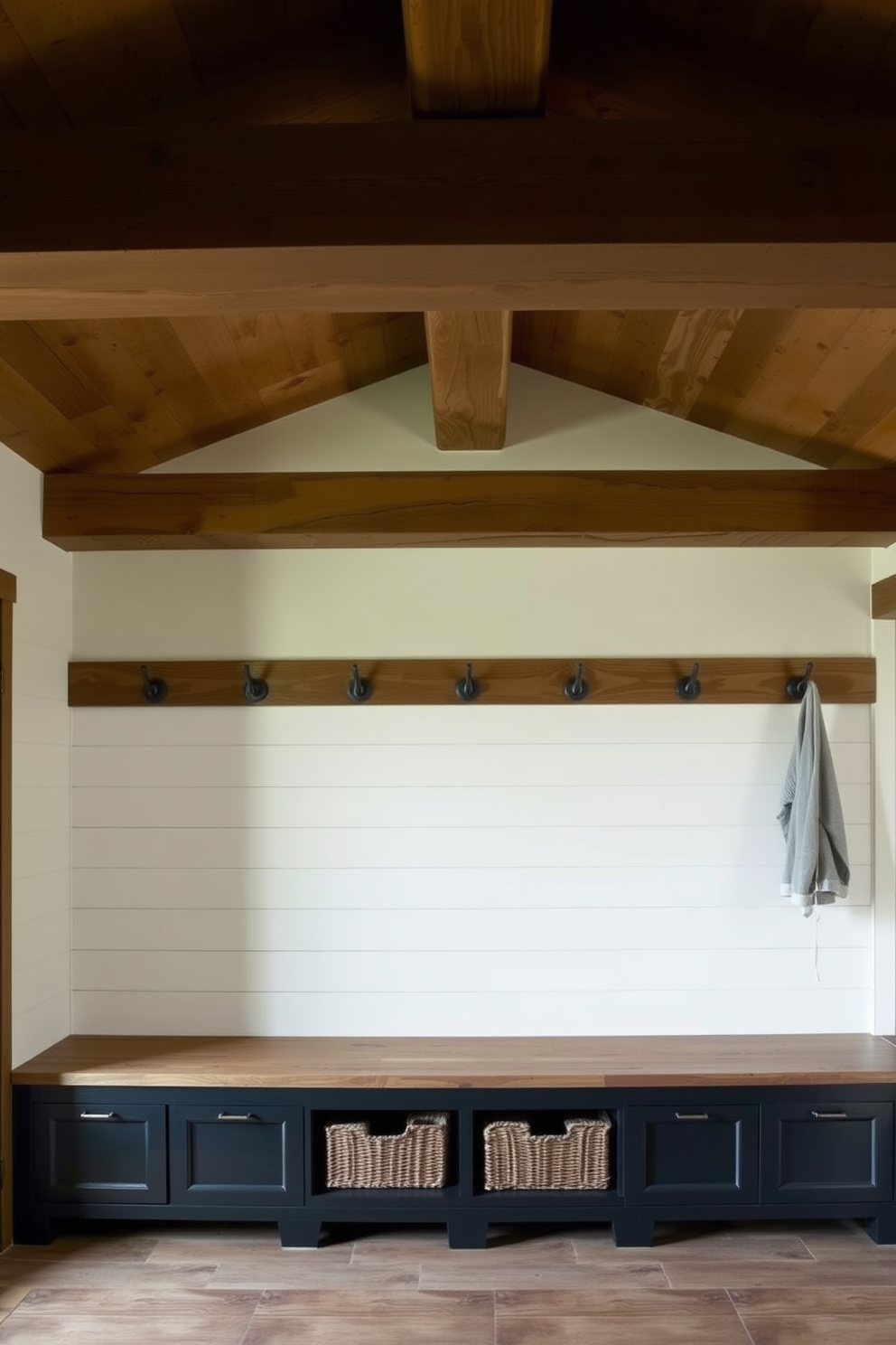 A rustic mudroom features wooden ceiling beams that add warmth and texture to the space. The walls are adorned with shiplap paneling, and a large bench with storage underneath provides a functional seating area.