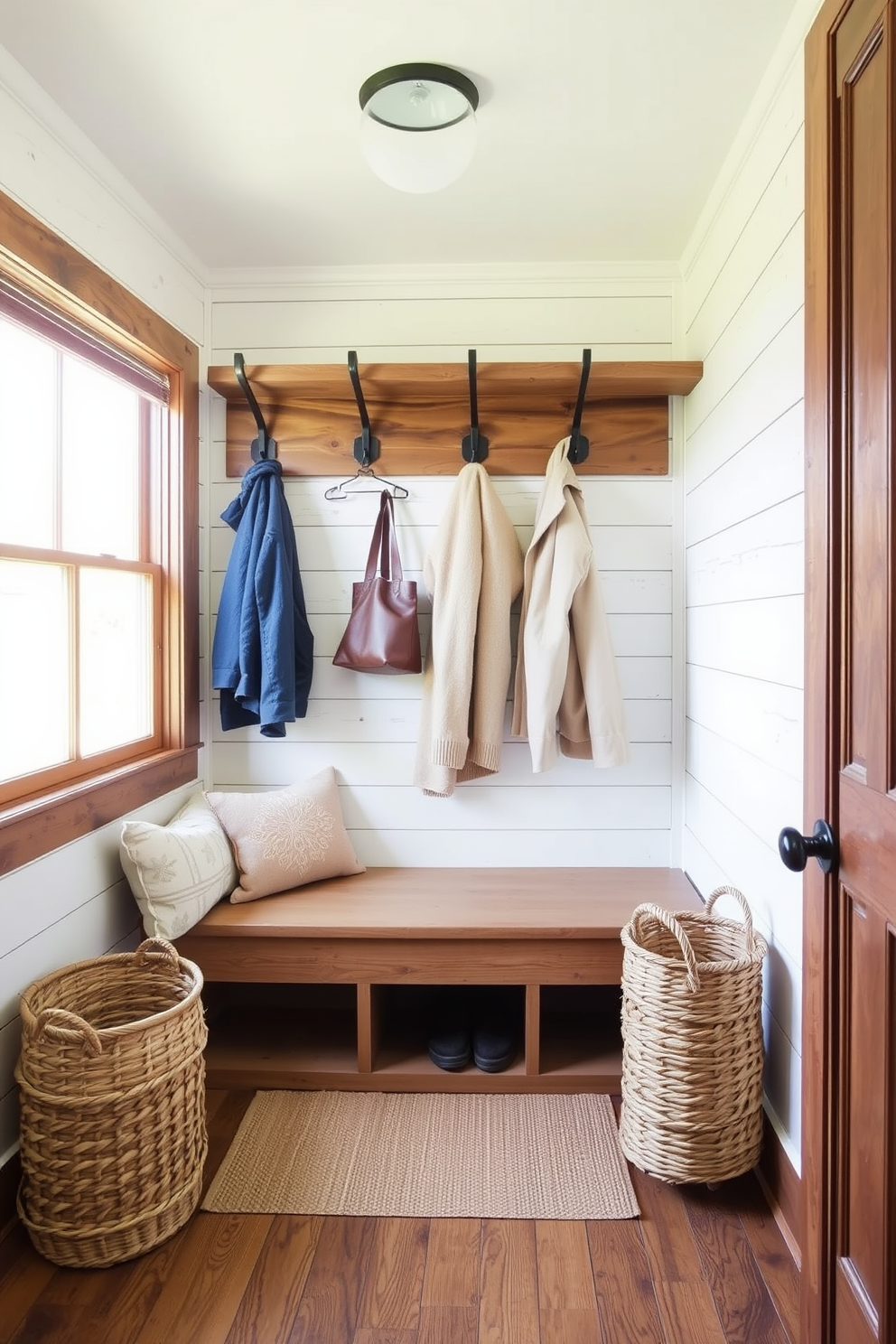 A cozy mudroom featuring shiplap walls that exude rustic charm. The space includes a built-in bench with plush cushions and hooks for hanging coats and bags. Natural light floods in through a large window, illuminating the warm wood tones and earthy color palette. A woven basket sits beside the bench for storing shoes and outdoor gear.