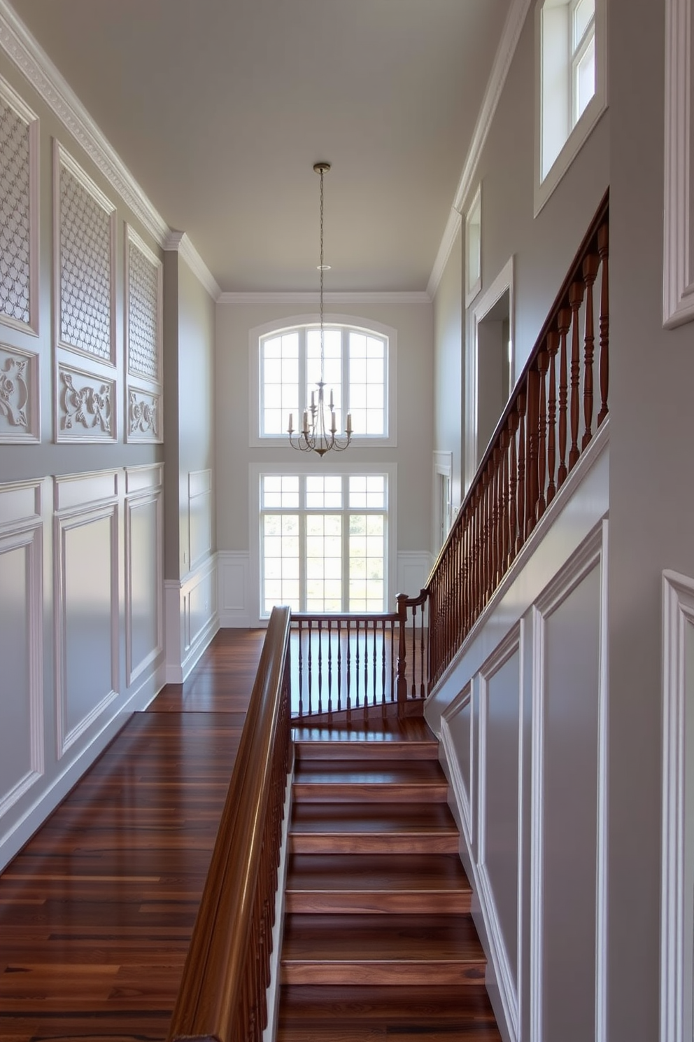 A grand staircase featuring decorative wall panels that add texture and elegance to the space. The panels are painted in a soft white color, complementing the rich wood of the staircase. The handrail is made of polished brass, creating a striking contrast with the dark wood steps. Large windows on the landing allow natural light to flood the area, enhancing the overall ambiance.