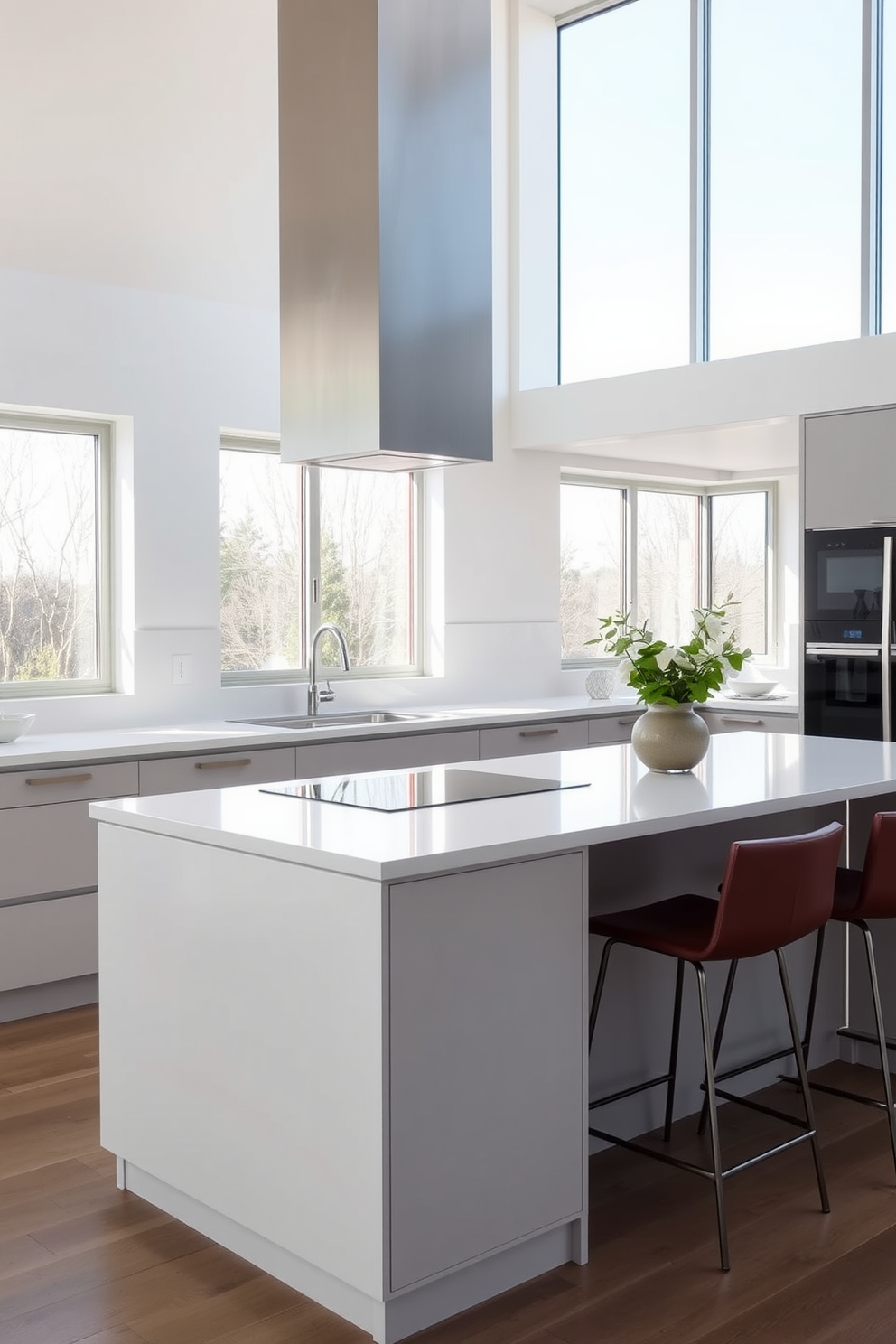 A simple kitchen design featuring sleek cabinetry with a matte finish and minimalist hardware. The countertops are made of white quartz, complemented by a subtle backsplash in soft gray tones. The kitchen island serves as a functional centerpiece with barstool seating on one side. Natural light floods the space through large windows, enhancing the airy and open feel of the room.