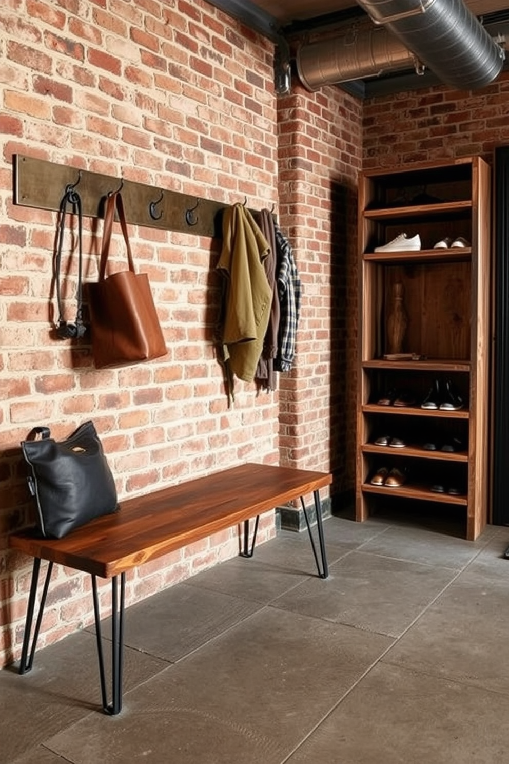 An industrial style mudroom features exposed brick walls and metal fixtures that create a raw yet inviting atmosphere. The space includes a sturdy wooden bench with metal legs, perfect for sitting while removing shoes, and hooks for hanging coats and bags. The floor is adorned with large concrete tiles that add to the rugged charm of the room. A minimalist shelving unit made of reclaimed wood provides storage for shoes and outdoor gear, completing the functional yet stylish design.