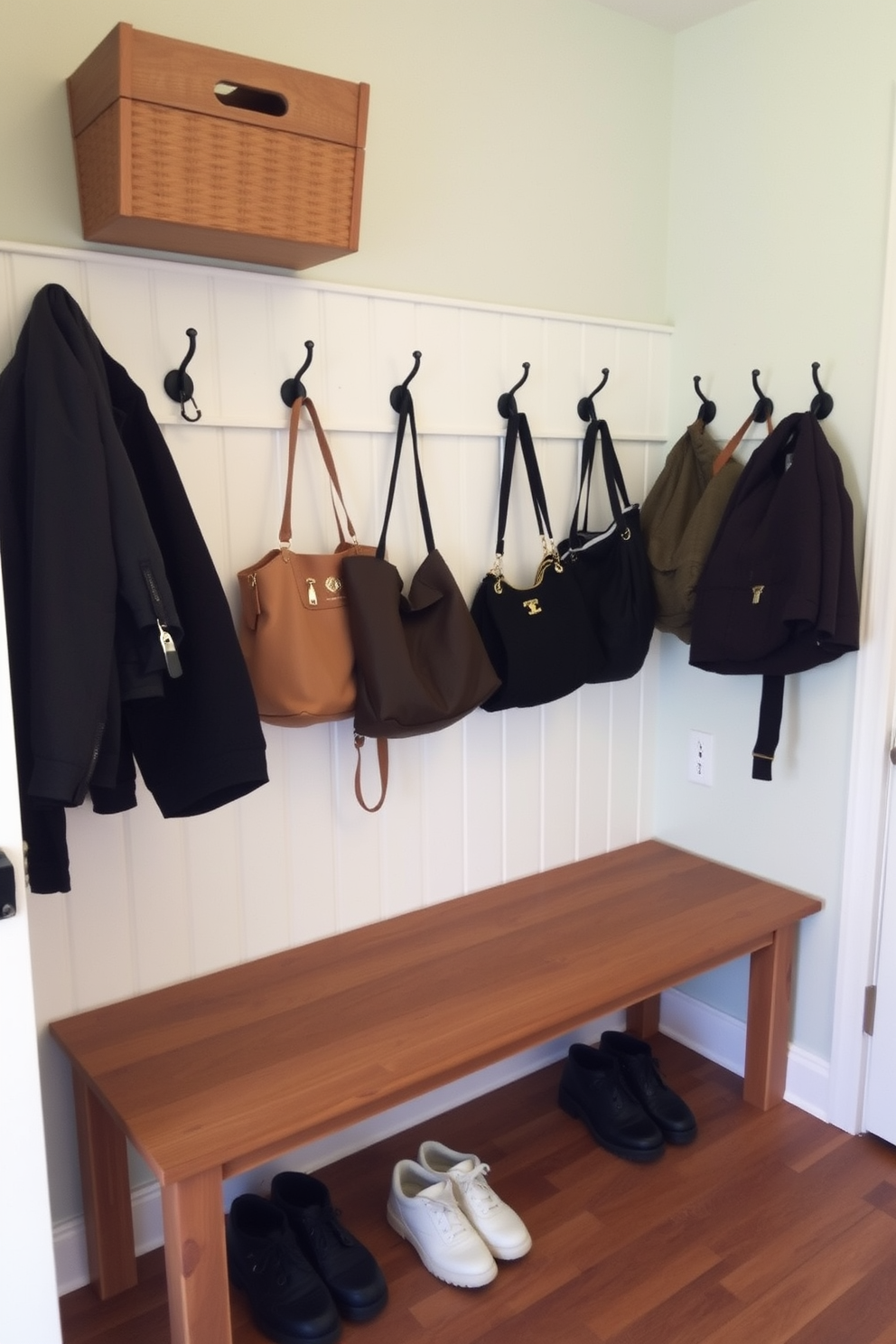 A functional mudroom features wall hooks arranged at varying heights for easy coat access. The space is enhanced with a bench for seating and storage baskets underneath to keep the area organized.