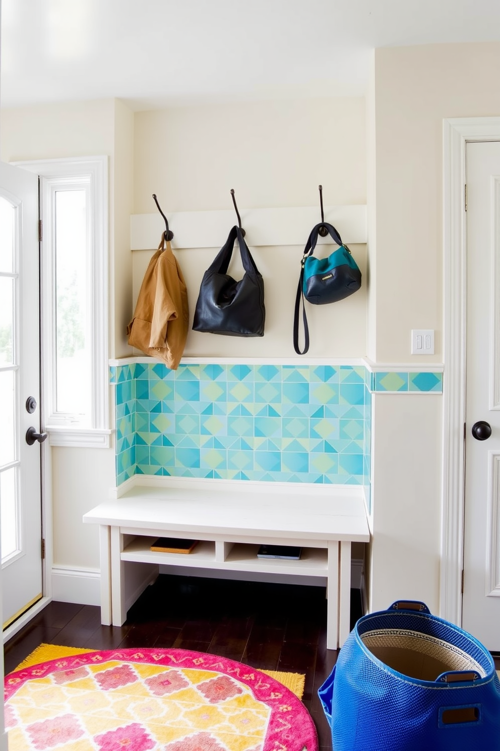 A functional mudroom features durable materials such as ceramic tile and hardwood that withstand heavy foot traffic. The design includes built-in benches for seating and storage cubbies for shoes and outerwear. Natural light floods the space through a large window, highlighting the neutral color palette of soft grays and whites. A stylish coat rack and a decorative mirror complete the look, providing both practicality and aesthetic appeal.