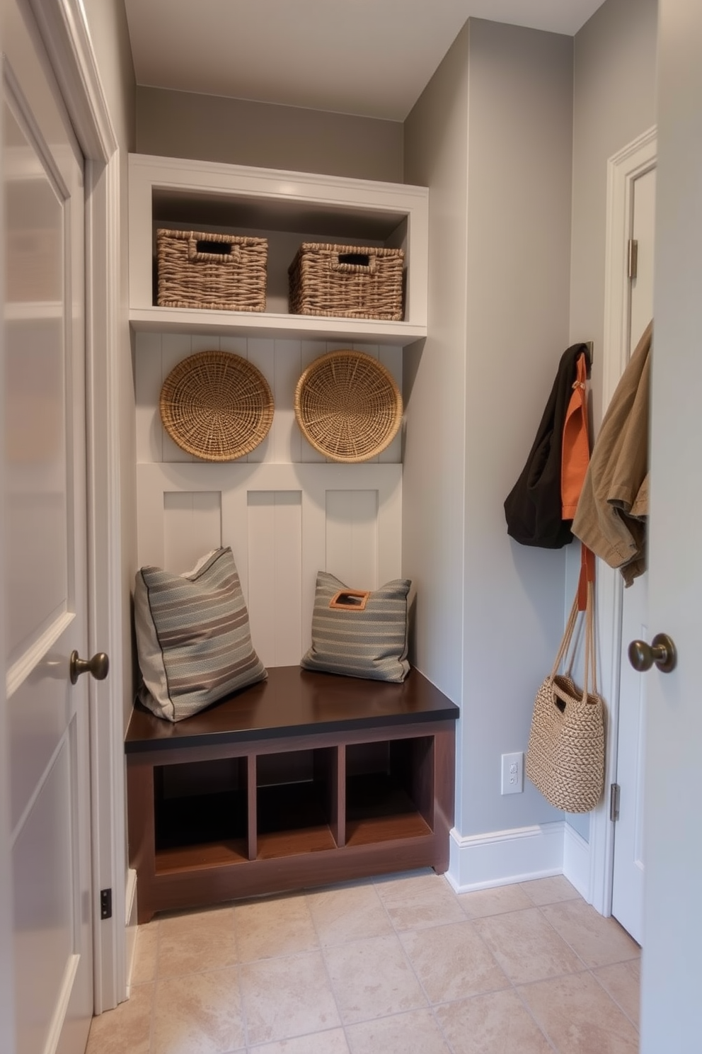 A functional mudroom with wall-mounted organizers for small items. The space features a bench with storage underneath and hooks for hanging coats and bags. The walls are painted in a light gray color, creating a bright and airy feel. Durable flooring options like ceramic tiles or vinyl provide easy maintenance and style.