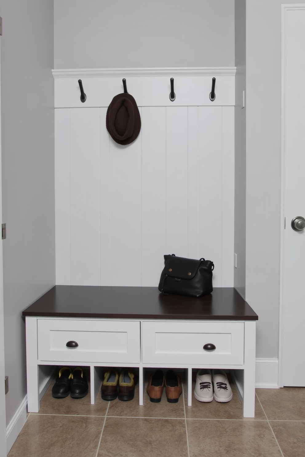 A functional corkboard is mounted on the wall, surrounded by hooks for hanging coats and bags. Below the corkboard, a bench with storage compartments provides a convenient spot for putting on shoes. The mudroom features a combination of open shelving and closed cabinets for organized storage. A durable tile floor is designed to withstand dirt and moisture, while a small area rug adds a touch of warmth.