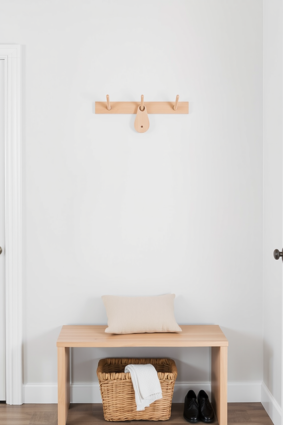 A sleek wall-mounted coat rack is positioned at eye level, made of natural wood with a minimalist design. Below it, a small bench offers a practical seating area, adorned with a plush cushion for comfort. The walls are painted in a light gray hue, creating a bright and airy atmosphere. A woven basket sits beneath the bench, providing stylish storage for shoes and accessories.