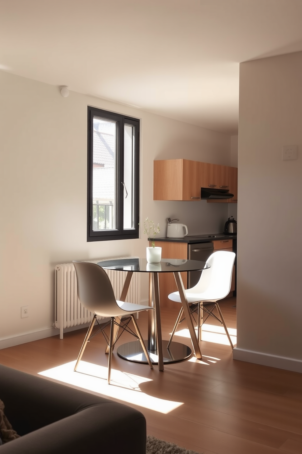 A compact dining table is elegantly placed against a wall in a cozy small apartment. Surrounding the table are four stylish chairs that complement the modern decor, creating an inviting space for meals and gatherings. Natural light streams in through a large window, illuminating the area with a warm glow. The walls are painted in a soft neutral tone, enhancing the sense of openness and airiness in the room.